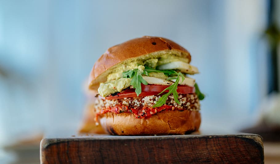 selective focus photography of hamburger with sliced tomatoes and vegetables, vegetable burger on brown wooden chopping block selective focus photography HD wallpaper