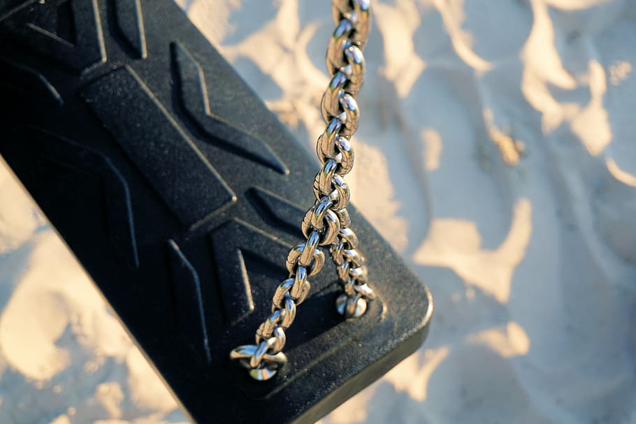 gray metal chain with black case near blue and white surface HD wallpaper