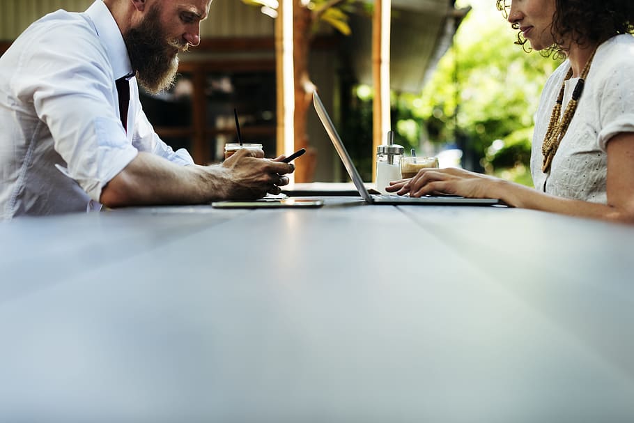 shallow focus photography of man and woman leaning on table HD wallpaper