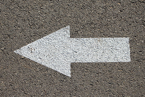 gray concrete surface with white arrow pointing at left side HD wallpaper