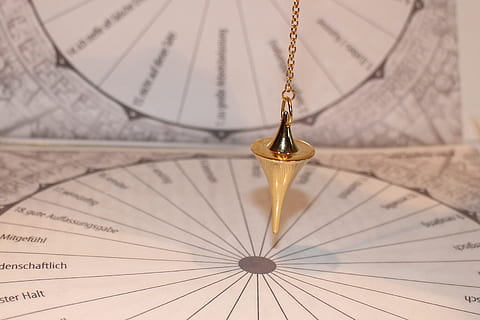 gold-colored hanging accessory near chart papers, pendulum HD wallpaper