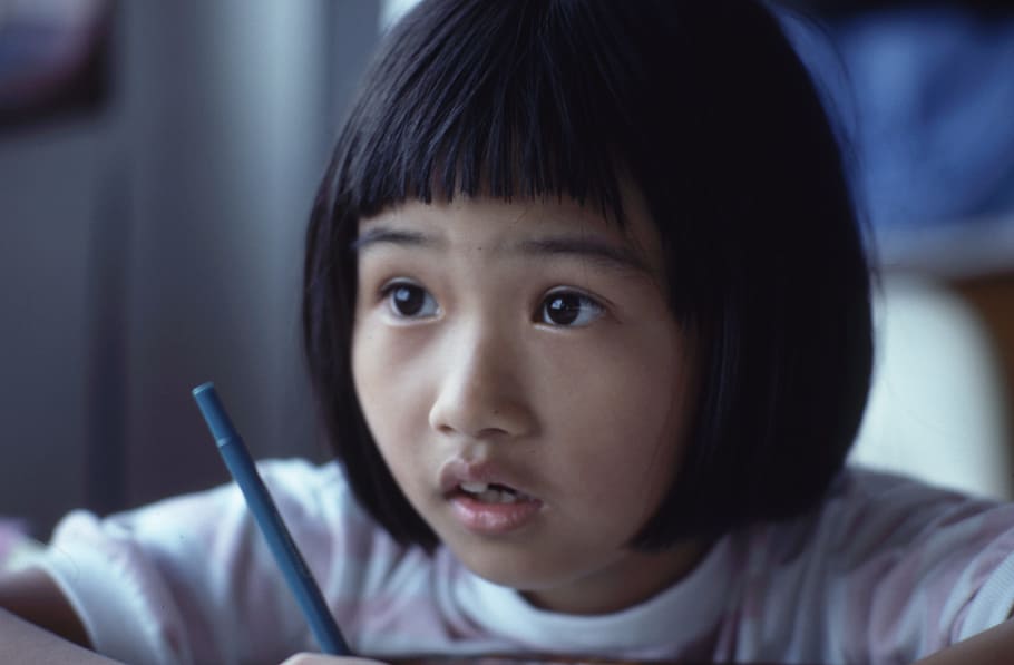 girl holding pen, closeup photography of girl holding blue pen HD wallpaper