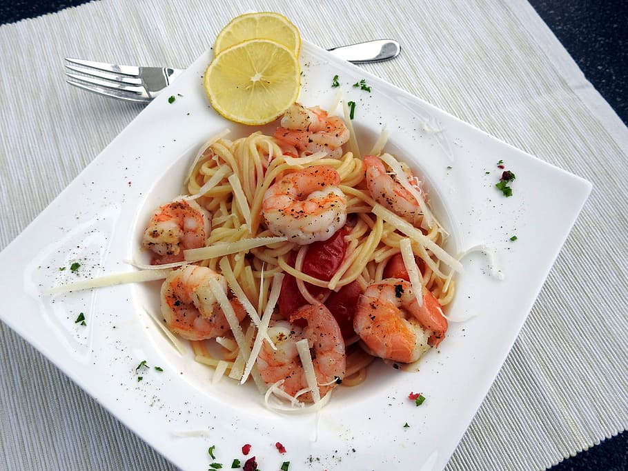 shrimp pasta on white plate with lemon garnish, spaghetti, noodles
