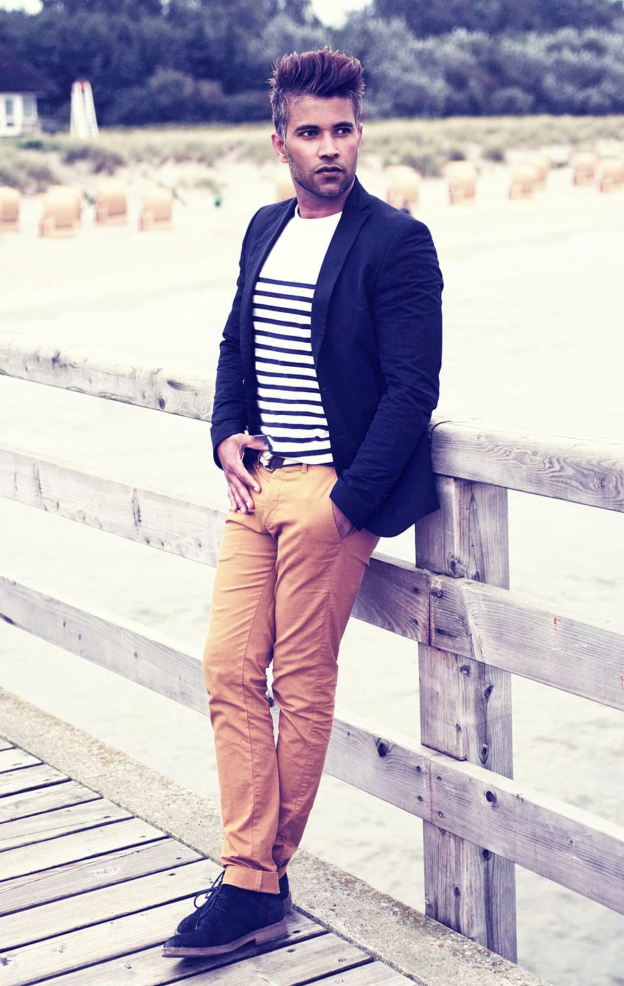 man wearing black notched lapel blazer and brown denim jeans while leaning on brown wooden fence during daytime HD wallpaper
