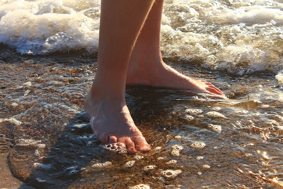person standing on seashore at daytime, water, feet, evening light HD wallpaper