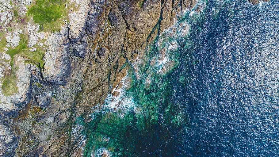 aerial photography of rocky shore near grass covered mountain, coastline, shore, ocean, rock, aerial, guernsey