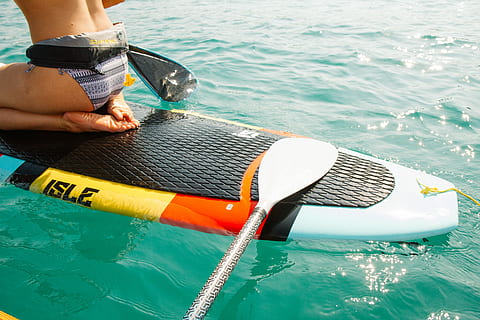 man riding paddle board, woman on white and multicoloired surfboard at daytime HD wallpaper