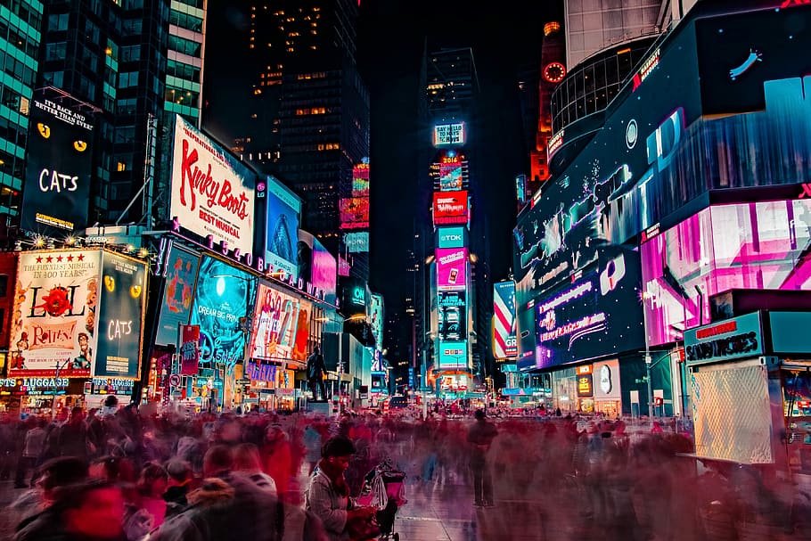 time-lapse photography of crowd of people on New York Time square during night time, people between buildings during nightstand