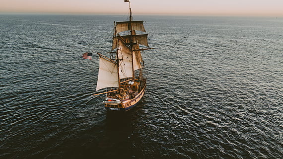 brown sailboat in beach under white sky, beige and white galleon ship on ocean HD wallpaper