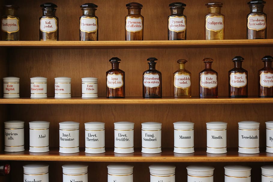 white labeled bottle and jar lot on brown wooden shelves, pharmacy
