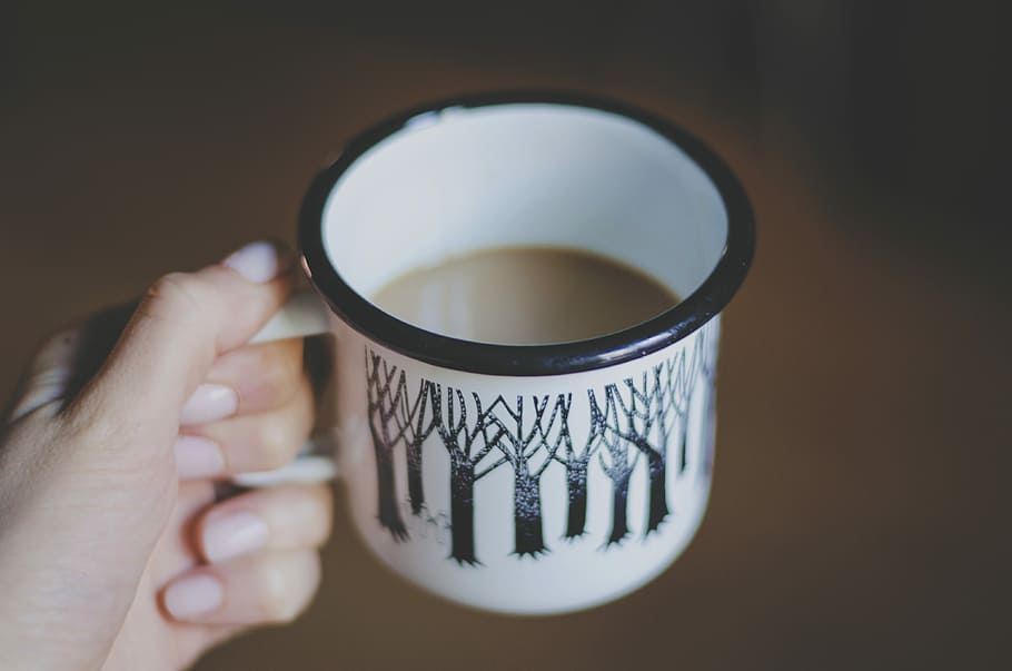 white and black ceramic mug filled with coffee, person holding white and black mug HD wallpaper