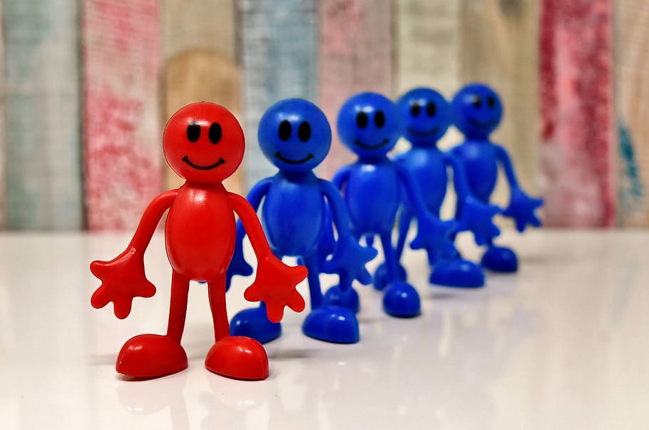 red and blue plastic toys on table, smilies, figures, together