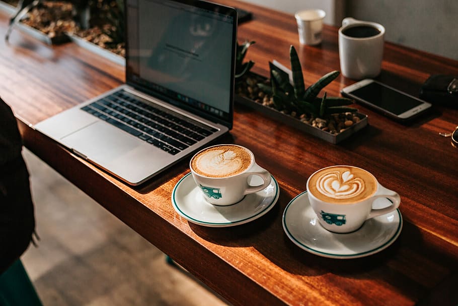 two cappuccino served on cups near laptop computer, white cup and saucer beside laptop HD wallpaper