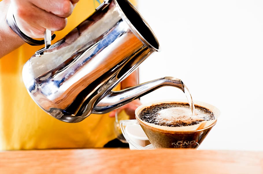 person pouring water on glass coffee cup, pitcher, hand, wooden HD wallpaper