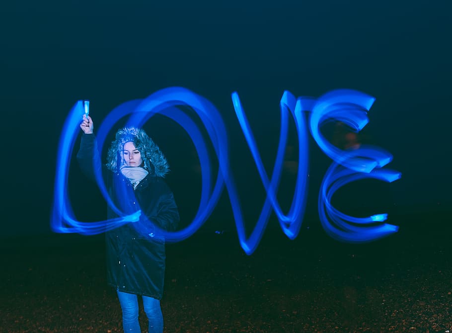high exposure photo of standing woman writing love word in the air using blue light pen, woman light writing time lapse photography HD wallpaper