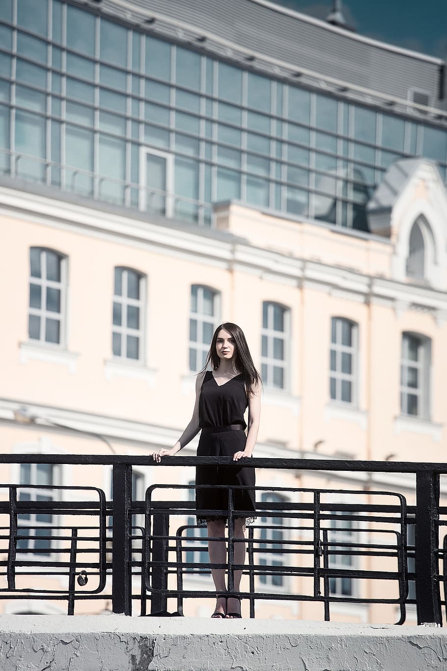 woman wearing black sleeveless dress on concrete bridge, woman in black