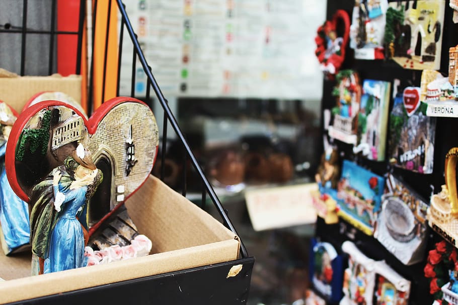 couple kissing figurine on top of rack near display of product packs, heart accessory in box HD wallpaper