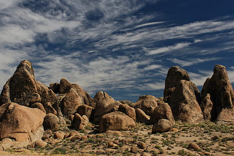 large rocks in desert, brown rock formation under blue sky at daytime HD wallpaper