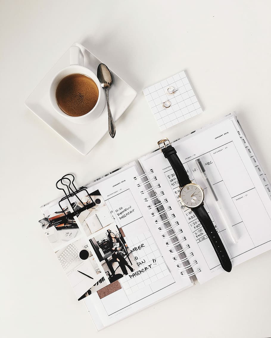 analog watch on top of book beside white ceramic teacup with teaspoon, round silver-colored chronograph watch on printed paper HD wallpaper