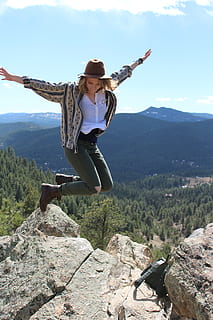 photo of woman jumping beside cliff during daytime, adventure HD wallpaper