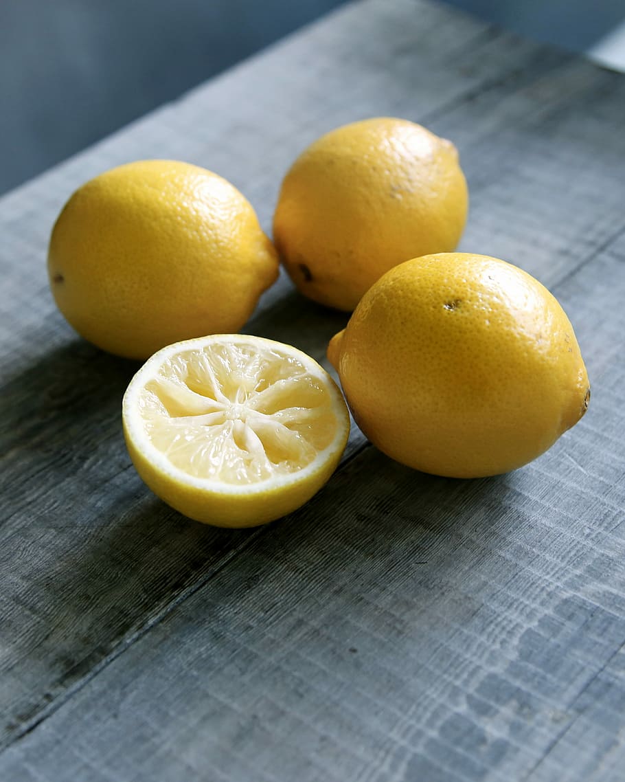 three yellow lemons beside sliced lemon placed on gray wooden surface, three lemons HD wallpaper