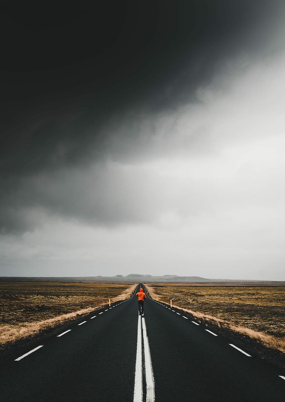 man under blacktop road under cloudy skies, person running in the middle of road HD wallpaper