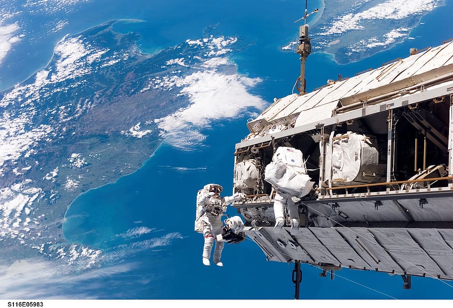 astronaut in space with near earth, spacewalk, space shuttle
