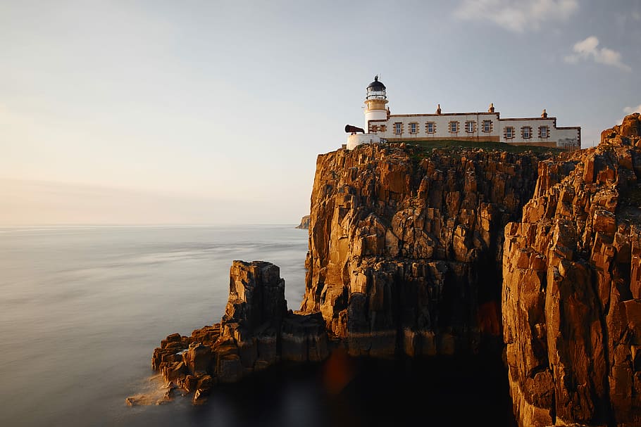 white concrete house on top of the brown mountain near body of water, white mosque on cliff HD wallpaper