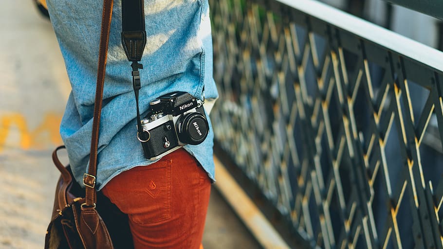 person carrying bag and camera facing fence, black DSLR Camera HD wallpaper