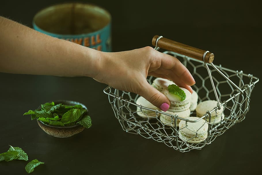 person holding macaroons near basket, human Hand, food, one person HD wallpaper