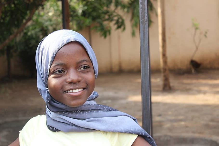 girl smiling wearing purple kiffeyeh, orphanage, tanzania, africa