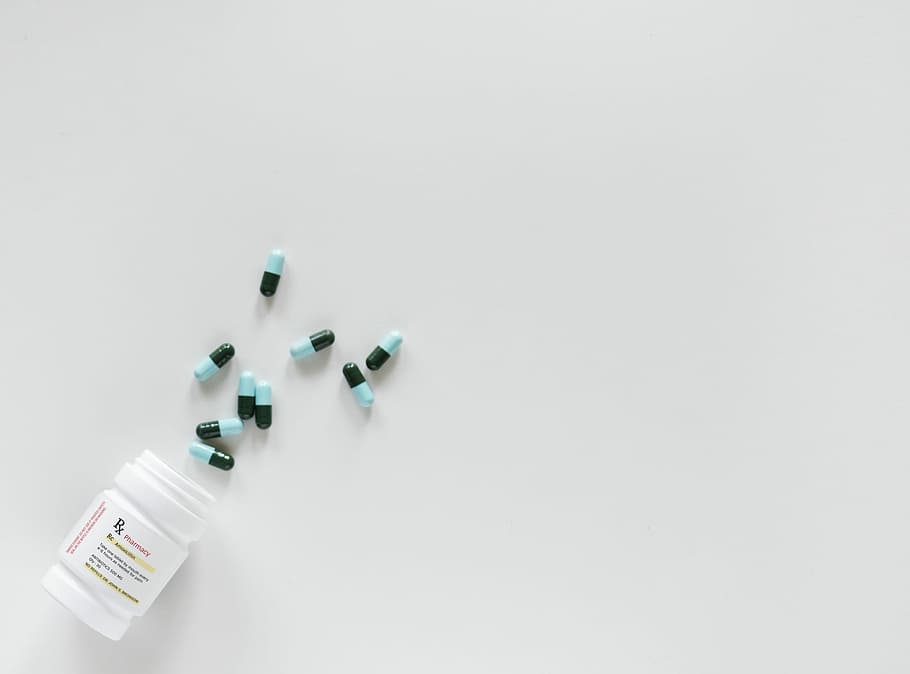 blue-and-black medication pills spilled from bottle, tablet, pharmacy