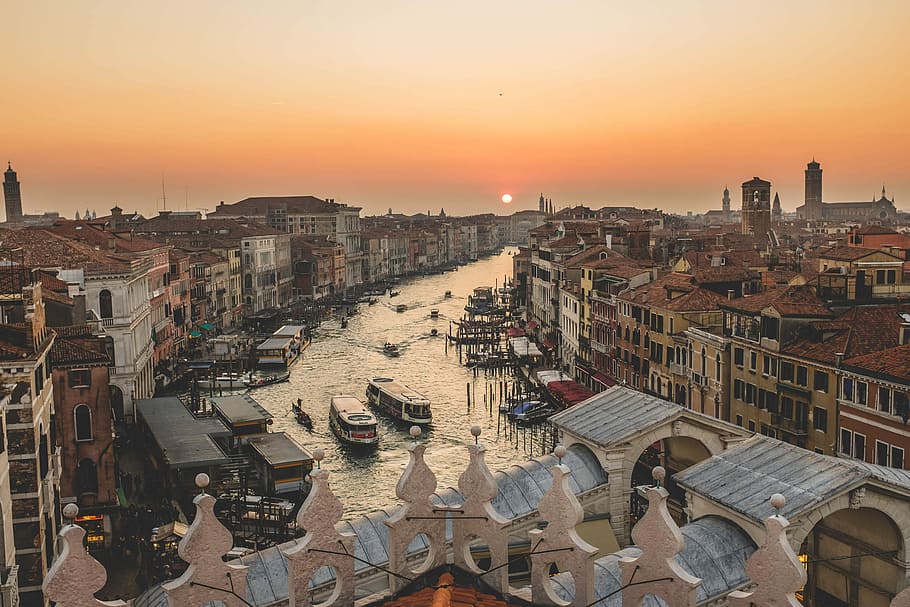 ships on body of water between houses and buildings during golden hour, high-angle photo body of water in the middle of establishment with boats HD wallpaper