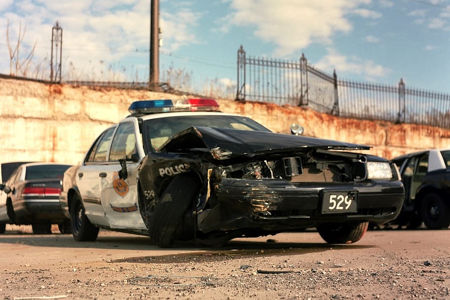 HD wallpaper: wrecked black and white police cruiser near other vehicles parked on lot at daytime - Wallpaper Flare