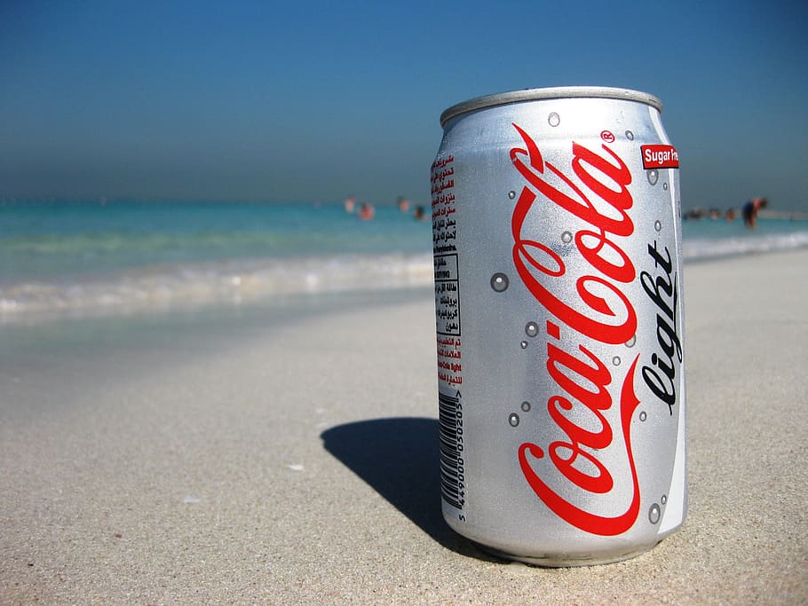 close-up photography of Coca-Cola Light can on beach, soft drinks