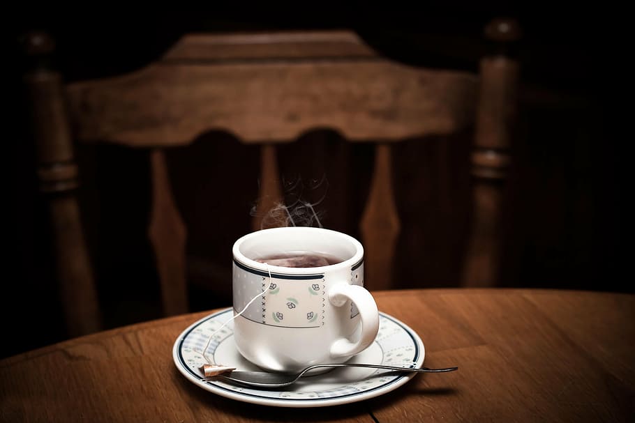 selective focus photo of white teacup with saucer on table, drink