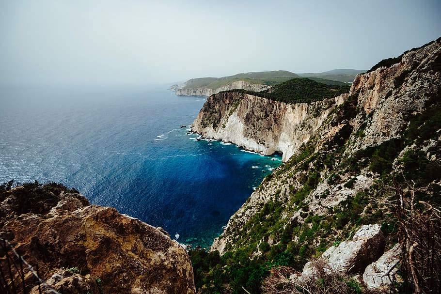 coastline under cloudy skies, aerial photography of cliff shore HD wallpaper