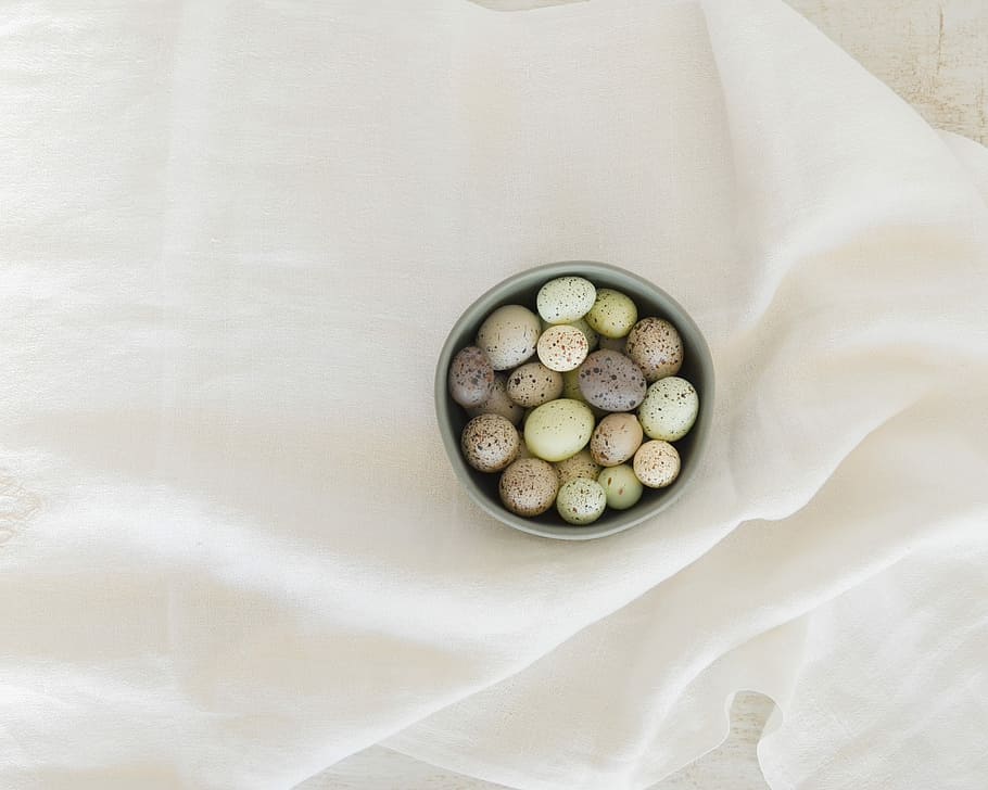 pebbles in gray ceramic bowl on white textile, assorted-color egg lot in bowl HD wallpaper