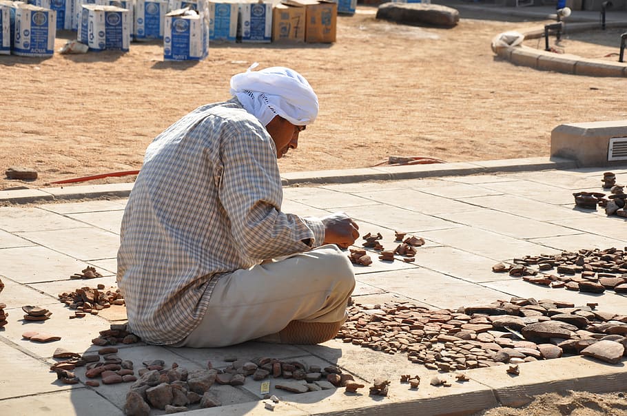 man sitting on concrete pathway near cardboard boxes, egypt HD wallpaper