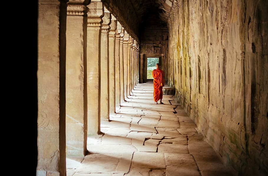 selective focus photography of monk at corridor, monk walking on concrete pathway HD wallpaper