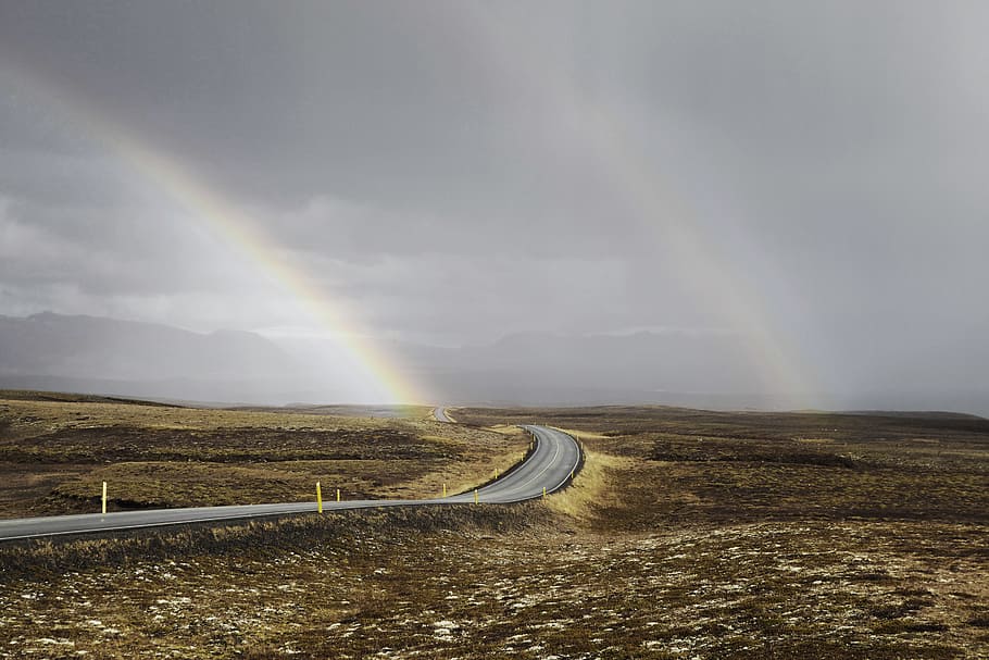 landscape photo of road under the rainbows, grey asphalt road under the cloudy sky HD wallpaper