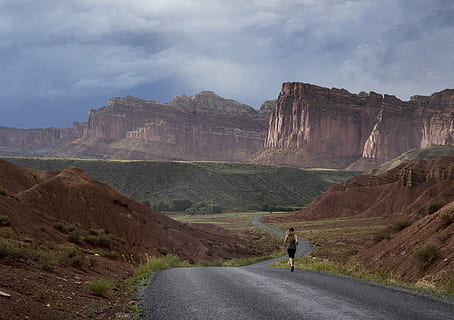 man running in road near mountain at daytime, jogger, landscape HD wallpaper