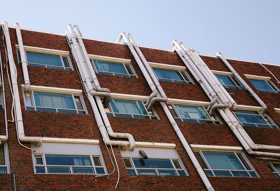 low-angle photography of brown concrete building under blue sky during daytime HD wallpaper