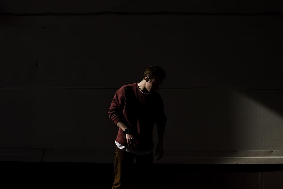man looking at the floor, man standing in front of white wall HD wallpaper