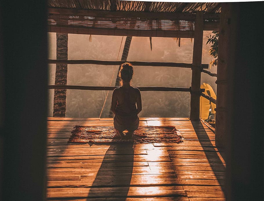 woman meditating on floor with overlooking view of trees, woman kneeling inside hut viewing trees HD wallpaper