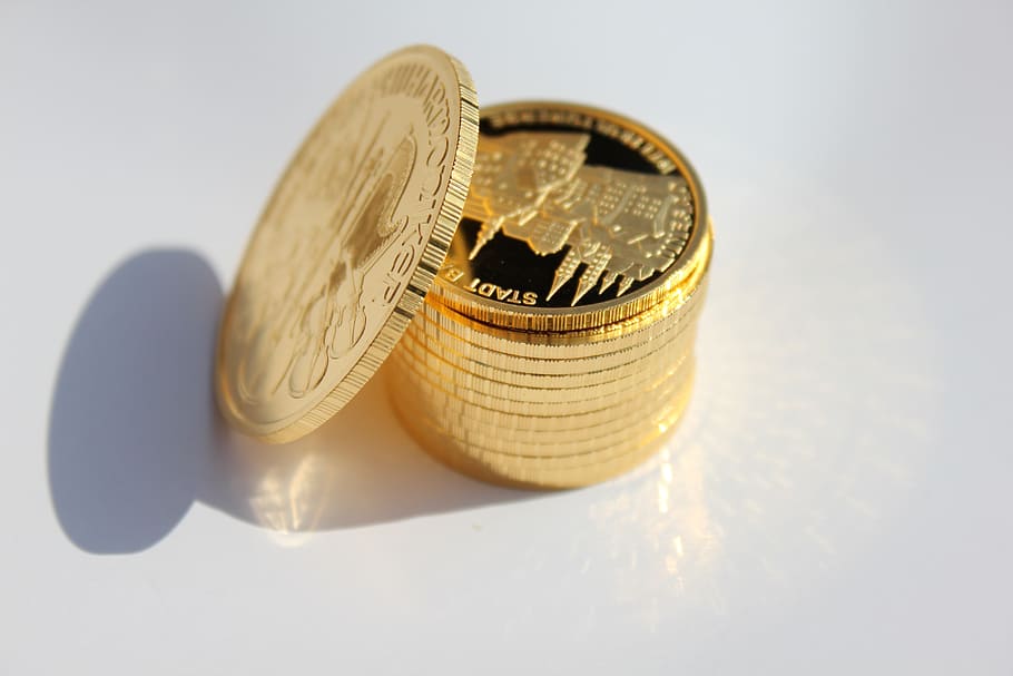 stack of round gold-colored coins, gold coin, metal, money, indoors