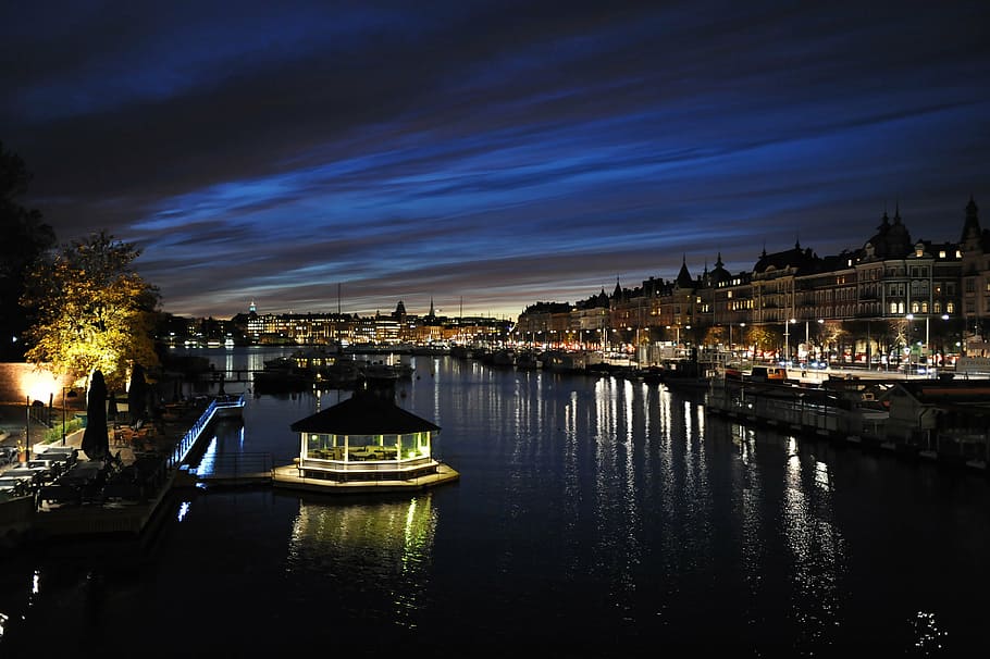 photo of river between city buildings and structures, sunset HD wallpaper