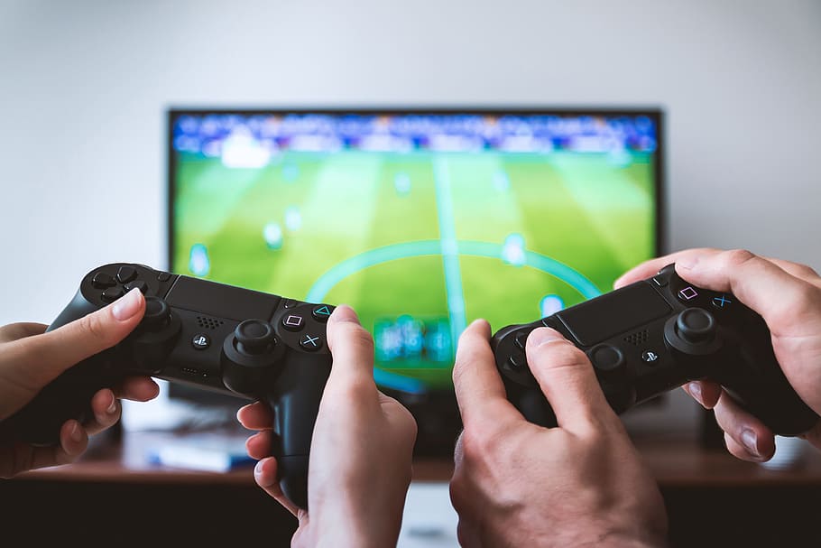 Two friends gaming on PlayStation and television, technology HD wallpaper
