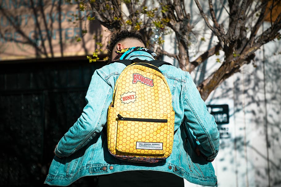 man wearing yellow backpack, person, jean jacket, fashion, tree HD wallpaper