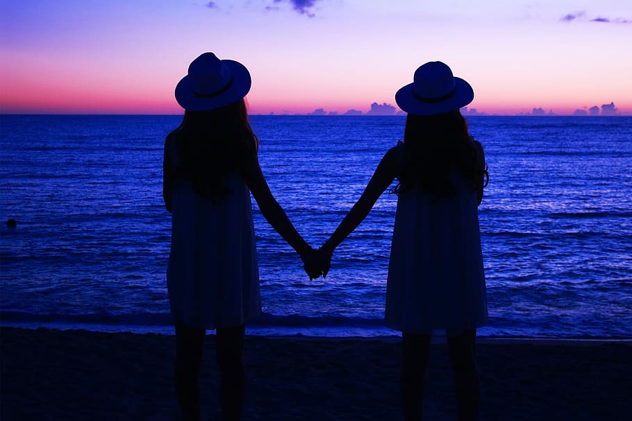 two woman holding beside sea shore, beach, sunset, women, people HD wallpaper